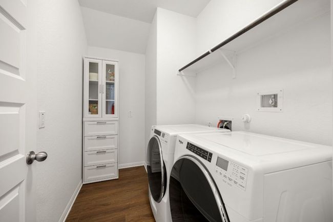 Laundry area featuring dark wood-style flooring and washing machine and dryer | Image 30