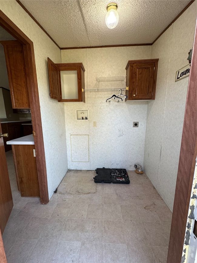 Laundry room featuring hookup for an electric dryer, washer hookup, a textured ceiling, and crown molding | Image 32