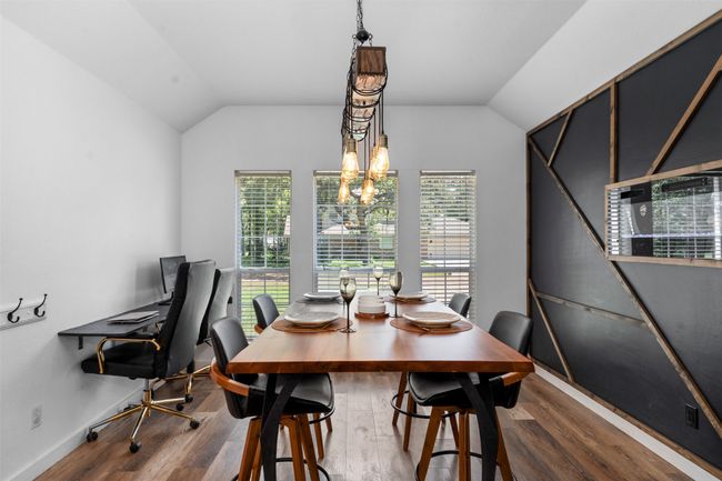 Dining space with dark wood-type flooring, vaulted ceiling, and a wealth of natural light | Image 9