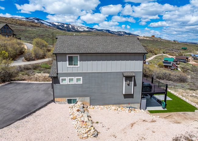 View of home's exterior with a shingled roof, board and batten siding, and a deck with mountain view | Image 54