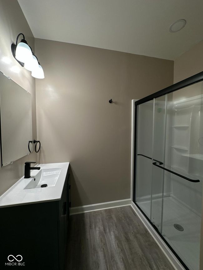 Unit 2 - Master bathroom with vanity, wood finished floors, and a stall shower | Image 22