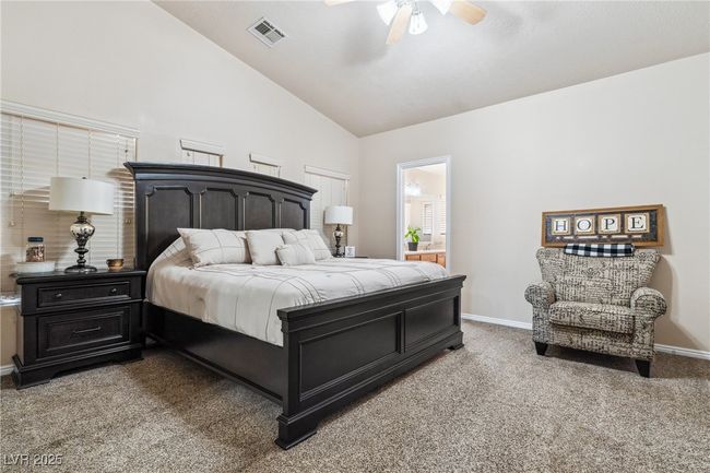 Bedroom with light colored carpet, baseboards, high vaulted ceiling, and ceiling fan | Image 27