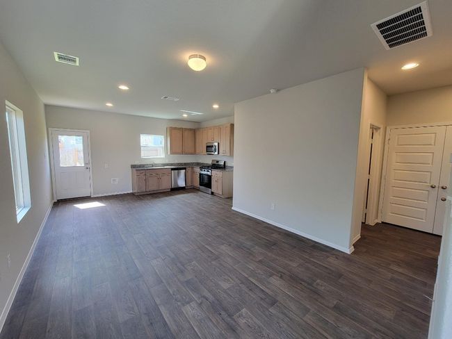 Unfurnished living room featuring dark wood-style flooring and recessed lighting | Image 7