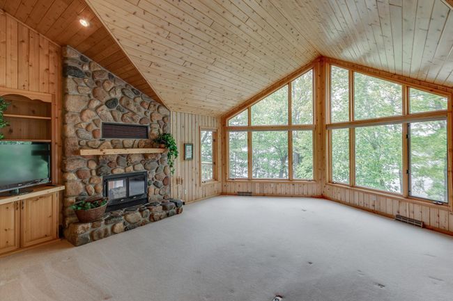 Look at this well designed home with natural wood interiors and stunning field stone fireplace! | Image 10