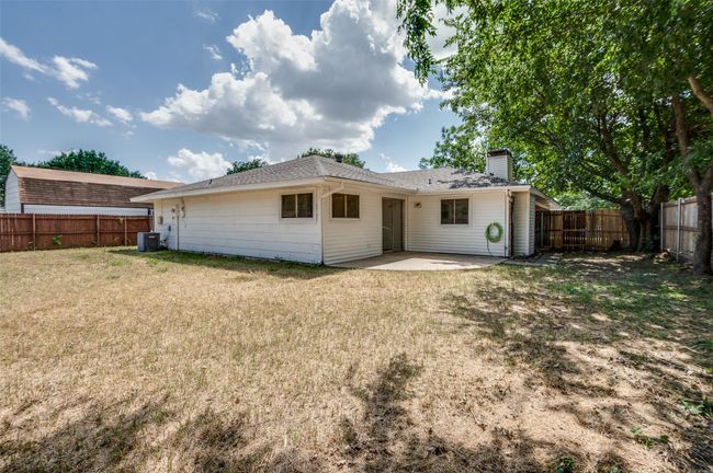 Rear view of property featuring a patio, a fenced backyard, and a chimney | Image 23