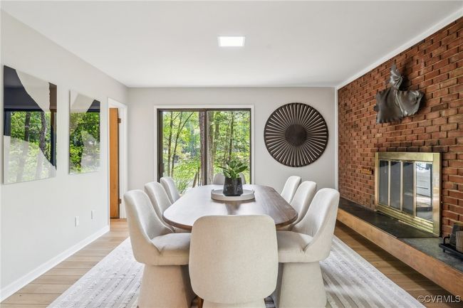 Dining area featuring a fireplace, light wood-style floors, and baseboards | Image 24