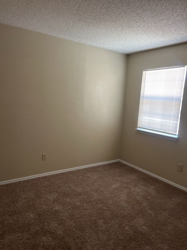 Empty room with a textured ceiling and carpet flooring | Image 4
