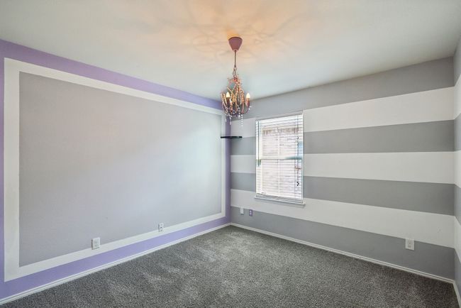 Carpeted empty room featuring baseboards and an inviting chandelier | Image 18