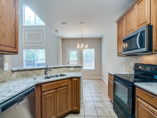 Kitchen featuring stainless steel appliances, brown cabinets, and backsplash | Image 7