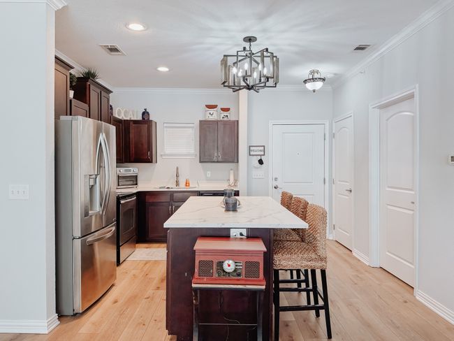 Kitchen featuring stainless steel appliances, a center island. Door to the right leads to the lock out bedroom. | Image 4