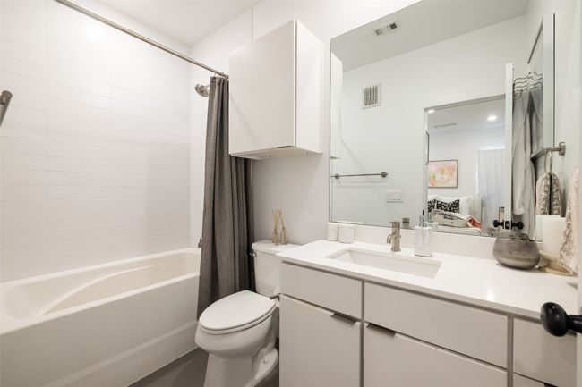 Full bathroom featuring shower / tub combo, vanity, visible vents, and toilet | Image 17