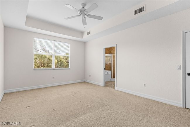 Unfurnished room with light colored carpet, ceiling fan, and a raised​​‌​​​​‌​​‌‌​‌‌​​​‌‌​​‌‌​‌​​​​​‌ ceiling | Image 22