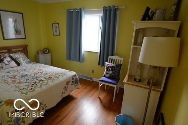 bedroom featuring visible vents, wood finished floors, and baseboards | Image 30