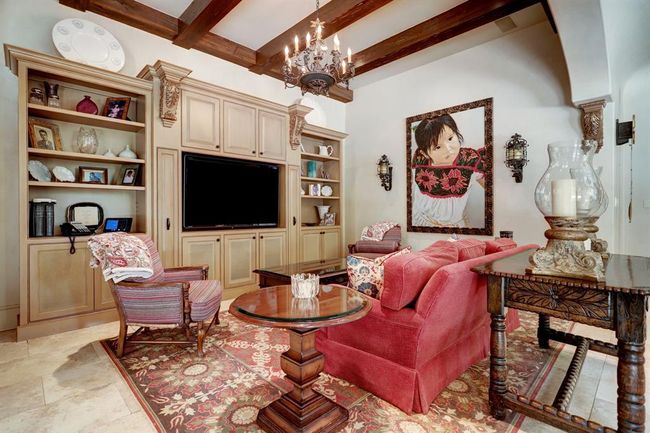 A closer view of the den. Beamed ceilings, built in cabinets, limestone floors, chandelier and recessed lighting. There is a half bath and small office off the kitchen and den. | Image 17