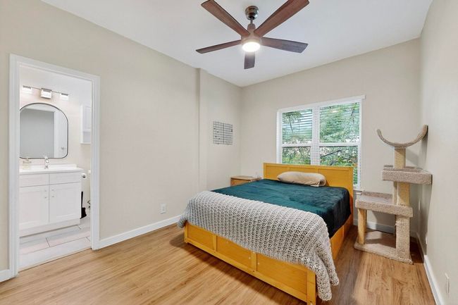 Bedroom featuring light wood-type flooring, ensuite bath, and ceiling fan | Image 18