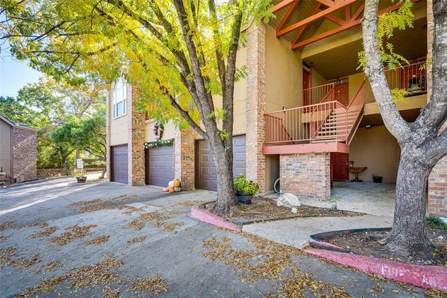 View of property featuring concrete driveway, stairs, and a garage | Image 18