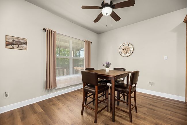 Dining room with dark wood-style flooring, baseboards, and ceiling fan | Image 9