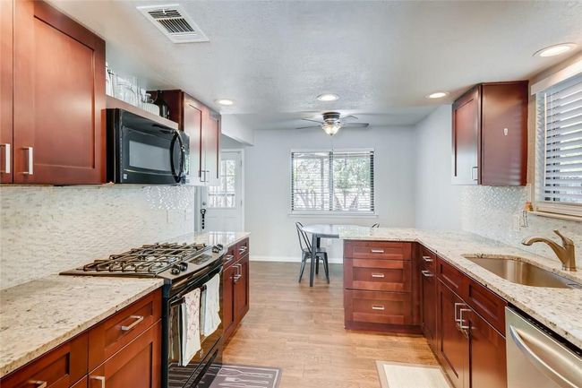 Kitchen featuring black appliances, a sink, light wood-type flooring, baseboards, and recessed lighting | Image 8