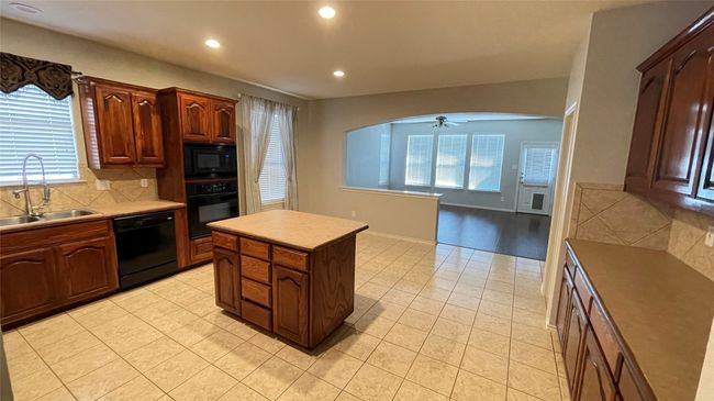 Kitchen with black appliances, recessed lighting, light tile patterned floors, and backsplash | Image 5
