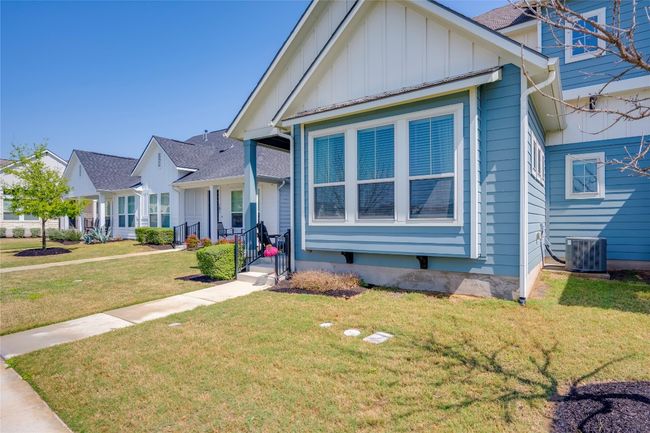 View of front of property featuring central AC unit, a front yard, board and batten siding, and roof with shingles | Image 31