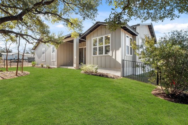 Rear view of house featuring fence, a yard, and board and batten siding | Image 27