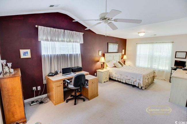 Bedroom featuring light carpet, lofted ceiling, an office area, and ceiling fan | Image 19