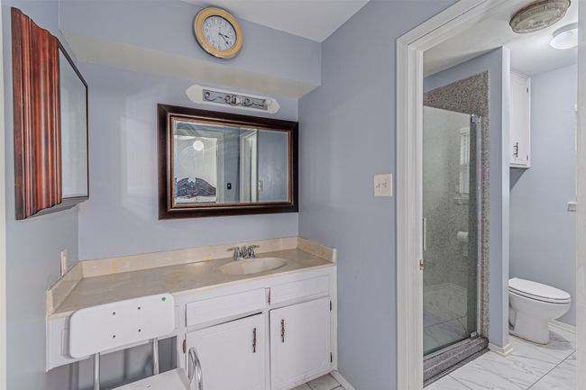 Bathroom with a shower stall, toilet, vanity, and marble finish floor | Image 17
