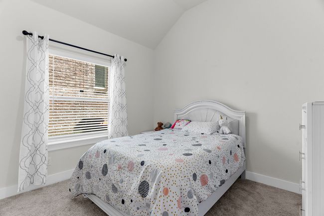 Bedroom with carpet floors, vaulted ceiling, and baseboards | Image 22