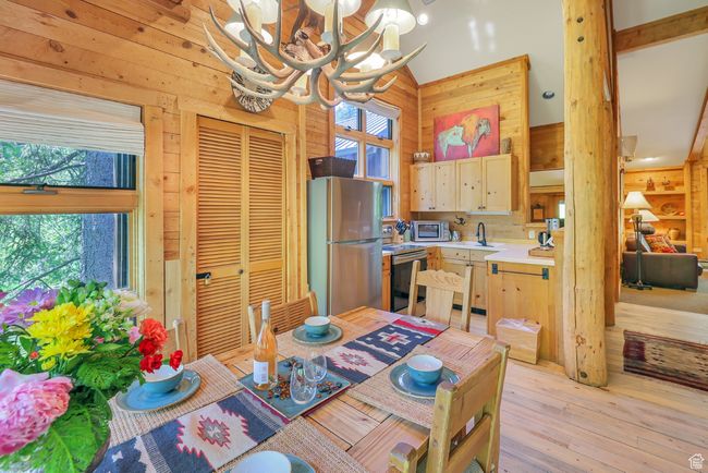 Dining space with 3 walls of windows, antler chandelier, wood floors and lofted ceiling | Image 16