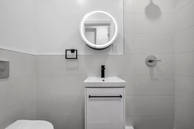 Bathroom featuring tile walls and vanity | Image 16