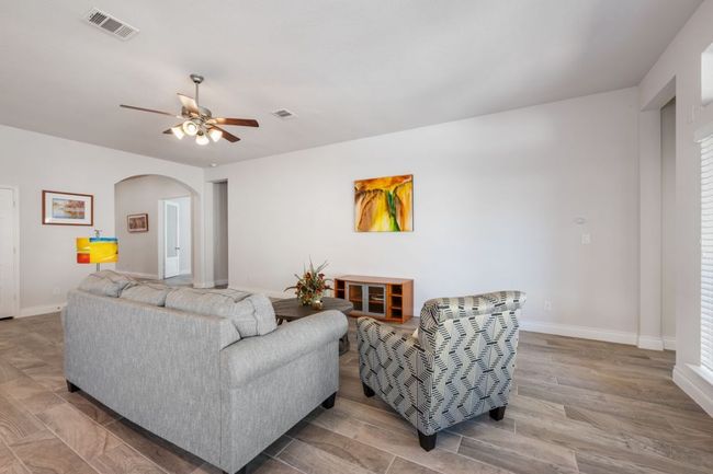 Living area featuring baseboards, visible vents, arched walkways, and ceiling fan | Image 12