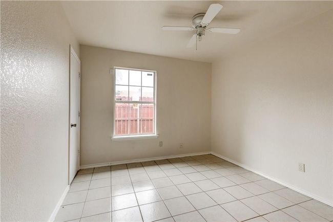 Spare room with a ceiling fan, light tile patterned flooring, and a textured wall | Image 12