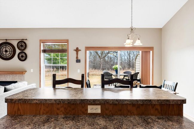Open-concept dining area with vaulted ceilings, seamlessly connected to the kitchen and living room for easy entertaining. | Image 15
