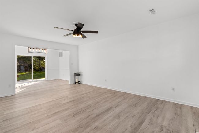 Unfurnished living room with light wood-style flooring, stairway, ceiling fan, and baseboards | Image 4