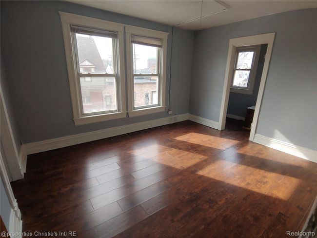 Spare room featuring baseboards and dark wood-style floors | Image 8