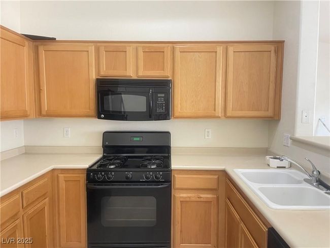 Kitchen with black appliances and light countertops | Image 12