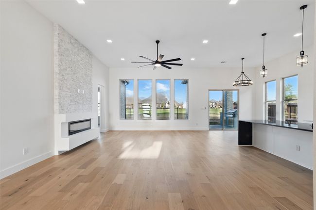 Unfurnished living room with a fireplace, recessed lighting, a ceiling fan, and light wood-type​​‌​​​​‌​​‌‌​‌‌​​​‌‌​​‌‌​‌​​​​​‌ flooring | Image 9