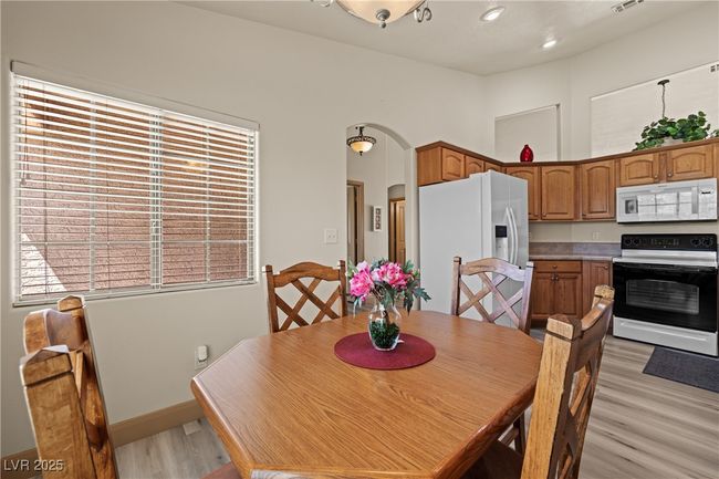 Dining space with arched walkways and light wood finished floors | Image 11