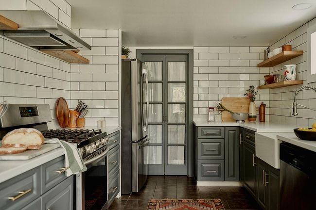 Kitchen with appliances with stainless steel finishes, ventilation hood, decorative backsplash, light countertops, and open shelves | Image 5