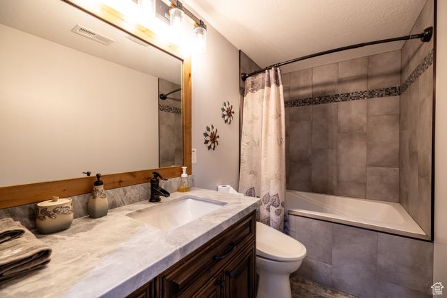 Full bath featuring vanity, tiled shower / bath combo, and a textured ceiling | Image 38
