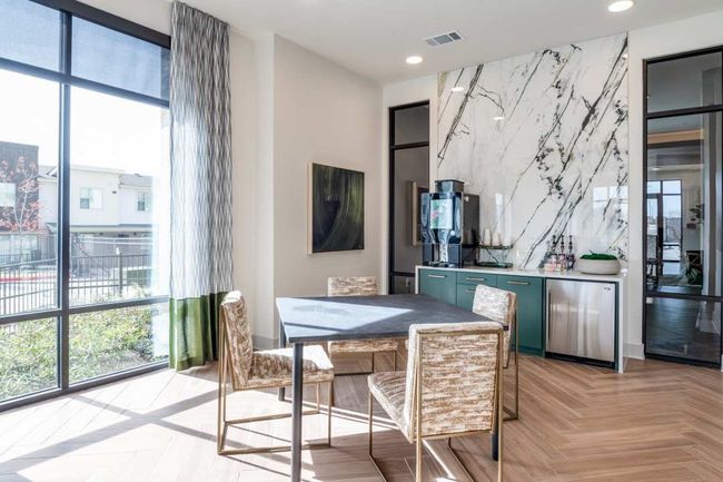Dining space with light parquet flooring, bar, and a wall of windows | Image 37