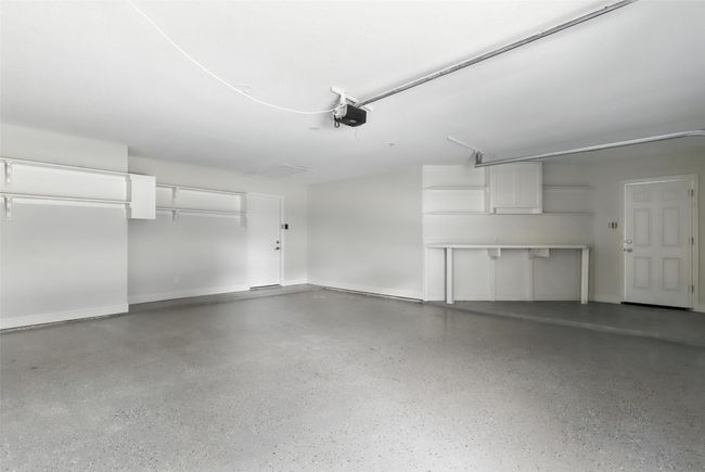 Garage with a garage door opener and baseboards | Image 38
