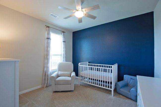 Carpeted bedroom with a crib, ceiling fan, baseboards, and visible vents | Image 33