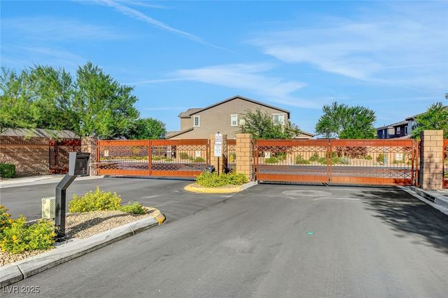 View of asphalt road featuring a gate, curbs, and a gated entry | Image 54
