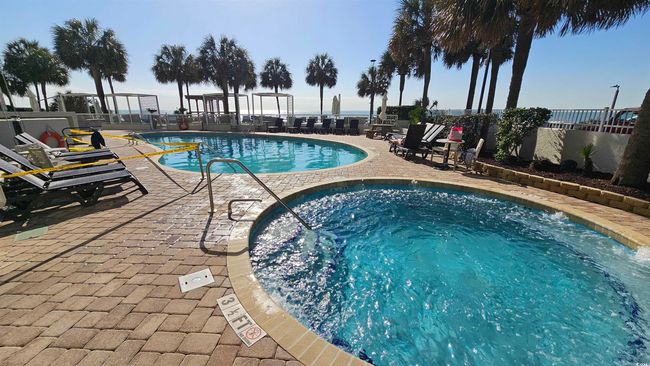 Pool with a patio area, fence, and a hot tub | Image 22