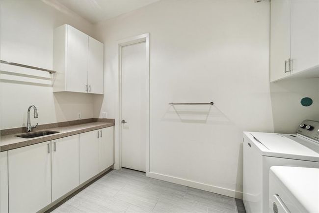 The second floor UTILITY ROOM includes tile flooring, stone countertop/backsplash, track lighting, built-in cabinets, electric and gas dryer connections. Its location is just off the the Primary Suite. | Image 26