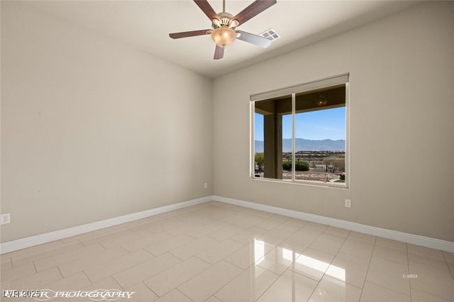 Unfurnished room with a mountain view, visible vents, baseboards, light tile patterned floors, and a ceiling fan | Image 38