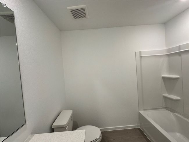 Bathroom with toilet, wood finished floors, baseboards, tub / shower combination, and vanity | Image 10