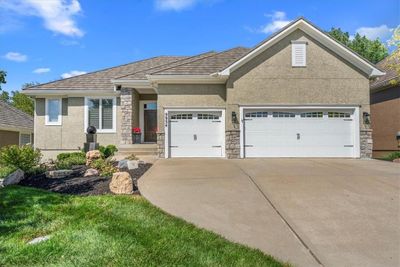 View of front of property with a front yard and a garage | Image 1