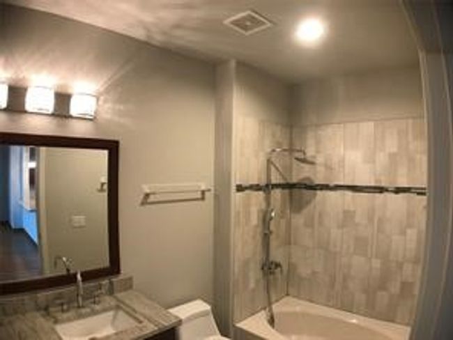 Bathroom with toilet, vanity, and shower / washtub combination | Image 14